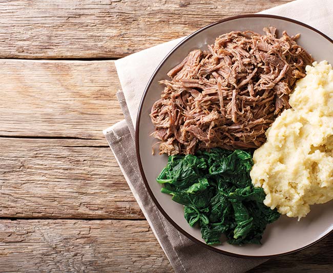 Botswana cuisine: seswaa beef stew with pap porridge and spinach close-up on a plate on a table. horizontal top view from above