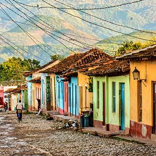 colourful traditional houses in Trinidad Cuba on cobbled streets mountains in the background