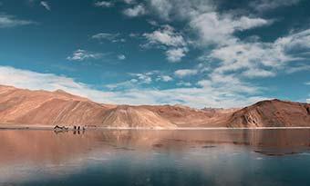 hiking in the mountains around the crystal clear lake in ladakh india