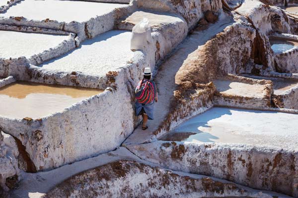 tour guides take the group through  maras village near the urubamba river as they trek on their holiday trekking adventure