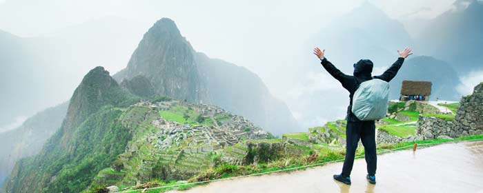 Adventure travel tourist celebrates reaching machu picchu after completing the inca trail trek on trip with Tucan Travel