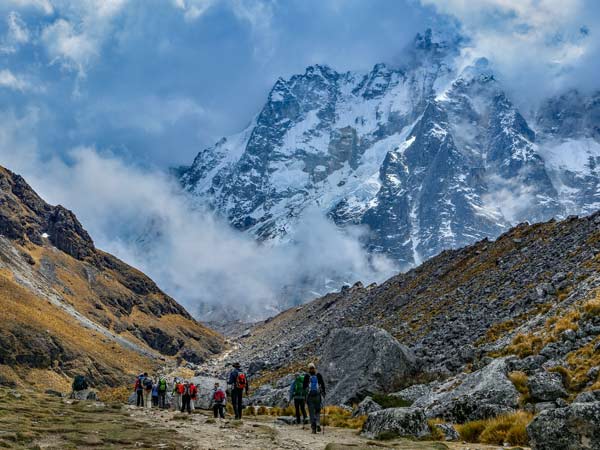 Group tour in Peru. Adventure travel tourists hiking on a group tour of Peru through the salkantay mountain range