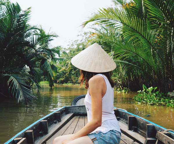 single female traveller on holiday in vietnam exploring the mekong delta by boat