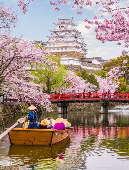 Tourists on the bridge viewing the gardens surrounding himeji castle in himeji, japan