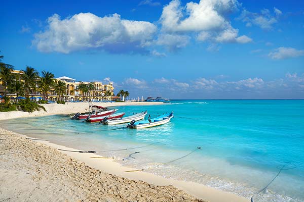 boats lined up in the shore of playa del carmen