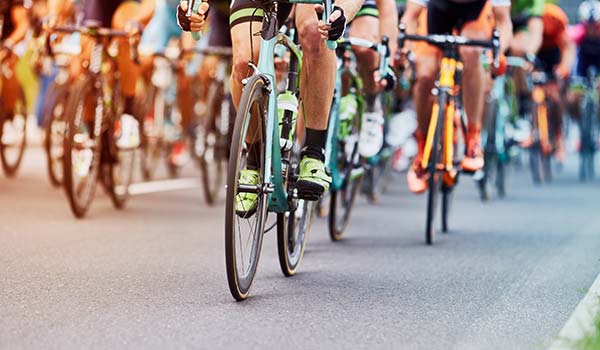 group of people riding bicycles on a road for the cape town cycle tour