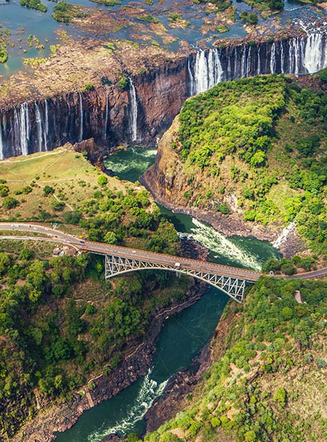 bridge road and green trees around victoria falls