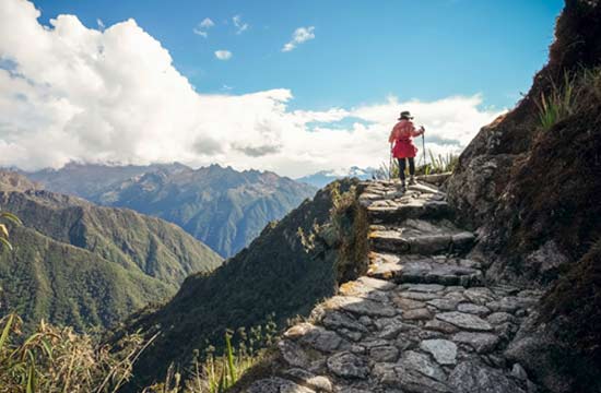 female solo traveler hikes the inca trail in search of adventure whilst on holiday with a tour group in peru